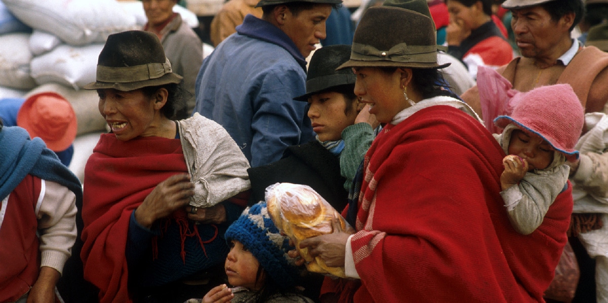 Ecuador. Mujeres con niños comprando en un mercado de Ecuador