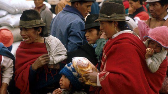 Ecuador. Mujeres con niños comprando en un mercado de Ecuador