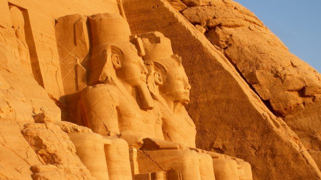 Egipto. Esculturas en la fachada de uno de los templos de Abu Simbel iluminados por la luz del sol al amanecer, en Egipto