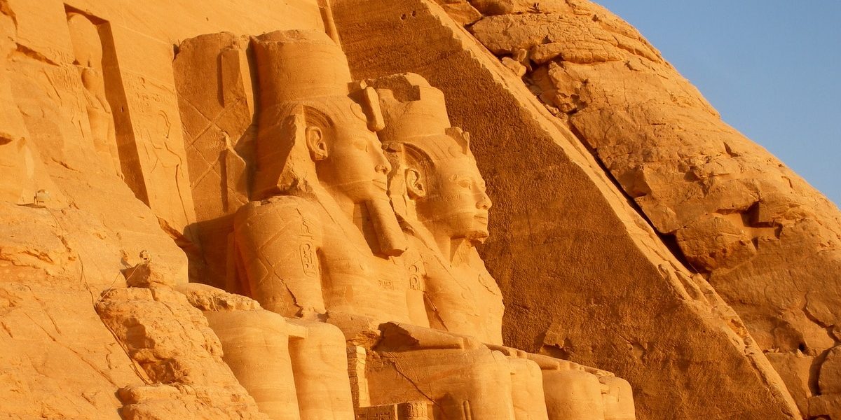 Egipto. Esculturas en la fachada de uno de los templos de Abu Simbel iluminados por la luz del sol al amanecer, en Egipto