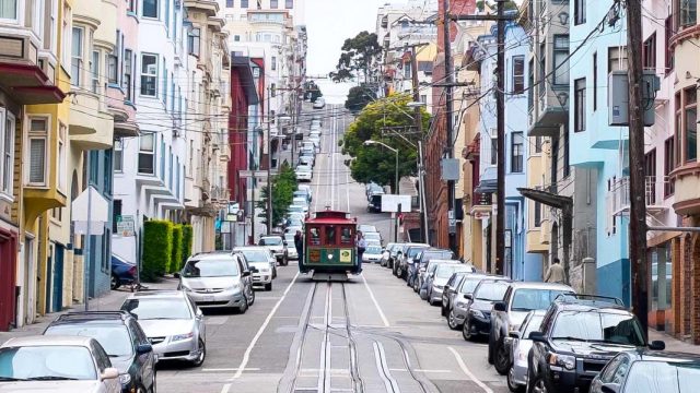 Estados Unidos. Calle en cuesta de SanFrancisco con tranvía y casas multicolores, en Estados Unidos